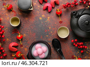 Frame made of bowl with tangyuan, teapot, fortune cookies and Chinese decor on grunge background. Dongzhi Festival. Стоковое фото, фотограф Pixel_shot / Фотобанк Лори