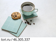 Drink coasters with cup of coffee, cookie and beans on white table. Стоковое фото, фотограф Pixel_shot / Фотобанк Лори