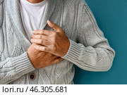 Mature man having heart attack on blue background, closeup. Стоковое фото, фотограф Pixel_shot / Фотобанк Лори