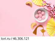 Bowl of tangyuan, fortune cookies, Chinese decor and sakura on pink background. Dongzhi Festival. Стоковое фото, фотограф Pixel_shot / Фотобанк Лори