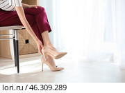 Tired young woman feeling ache in legs indoors. Стоковое фото, фотограф Pixel_shot / Фотобанк Лори