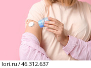 Woman with glucose sensor for measuring blood sugar level and applicator on pink background, closeup. Diabetes concept. Стоковое фото, фотограф Pixel_shot / Фотобанк Лори