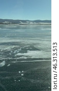 Vertical video of Lake Baikal in winter. Traditional journey on the ice of the frozen Smal Sea to Cape Khoboy - Olkhon Island attractions on sunny February day. Winter landscape. Natural background. Стоковое видео, видеограф Виктория Катьянова / Фотобанк Лори