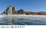 LAKE BAIKAL, KHUZHIR VILLAGE, OLKHON ISLAND, IRKUTSK REGION, RUSSIA -  February 22, 2025: Video of tourists walking on ice of frozen Small Sea near famous Shamanka Rock - natural landmark of lake. Редакционное видео, видеограф Виктория Катьянова / Фотобанк Лори