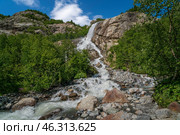 View of the Alibek waterfall formed by the fall of the Jalovchatka River from the Alibek glacier on a sunny summer day, Dombay, Karachay-Cherkessia, Russia. Стоковое фото, фотограф Ula Ulachka / Фотобанк Лори