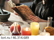 Female alchemist with spell book making elixir in laboratory. Стоковое фото, фотограф Pixel_shot / Фотобанк Лори