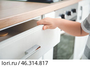 Little boy opening drawer with cutlery at home. Стоковое фото, фотограф Pixel_shot / Фотобанк Лори