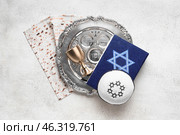 Passover Seder plate with kippah, Torah, matza and cup on grunge background. Стоковое фото, фотограф Pixel_shot / Фотобанк Лори