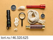 Vintage spyglass, compass, magnifier, flashlights, rope and seashells on color background. Стоковое фото, фотограф Pixel_shot / Фотобанк Лори