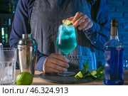 Barkeeper preparing Blue Lagoon cocktail at table in bar. Стоковое фото, фотограф Pixel_shot / Фотобанк Лори