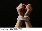 Female hostage with tied hands on dark background, closeup. Стоковое фото, фотограф Pixel_shot / Фотобанк Лори