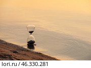 Stylish hourglass near river at sunset. Стоковое фото, фотограф Pixel_shot / Фотобанк Лори