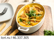Baking dish with tasty conchiglioni pasta on table. Стоковое фото, фотограф Pixel_shot / Фотобанк Лори