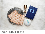 Passover Seder plate, flatbread matza, kippah and Torah on light background. Стоковое фото, фотограф Pixel_shot / Фотобанк Лори