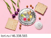 Passover Seder plate with traditional food and kippah on color background. Стоковое фото, фотограф Pixel_shot / Фотобанк Лори