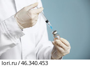 Cosmetologist holding syringe with filler and ampule on color background, closeup. Стоковое фото, фотограф Pixel_shot / Фотобанк Лори