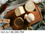 Wooden board with assortment of tasty cheese on table. Стоковое фото, фотограф Pixel_shot / Фотобанк Лори