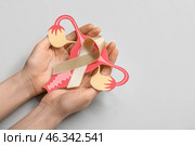 Woman with beige ribbon and paper uterus on light background. Cancer awareness concept. Стоковое фото, фотограф Pixel_shot / Фотобанк Лори