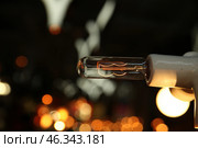 Лампочка с горящими нитями накаливания на темном фоне огней города. Стоковое фото, фотограф Ольга Зиновская / Фотобанк Лори