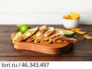 Board with tasty quesadillas and lime on wooden background. Стоковое фото, фотограф Pixel_shot / Фотобанк Лори