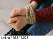 Female hostage with tied hands sitting on floor in room, closeup. Стоковое фото, фотограф Pixel_shot / Фотобанк Лори
