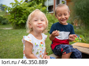 Довольная маленькая девочка со своим братом на природе. Дети отдыхают летом на даче. Стоковое фото, фотограф Елена Болтунова (Галиуллина) / Фотобанк Лори