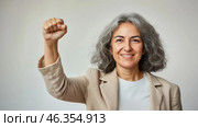 Middle aged latin american woman with raised fist symbolizing empowerment, strength and women solidarity, International Womens Day concept. Стоковое AI-изображение, AI-художник Анастасия Золотницкая / Фотобанк Лори