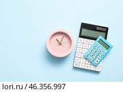 Alarm clock with calculators on color background. Стоковое фото, фотограф Pixel_shot / Фотобанк Лори