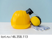 Hardhat with ear protectors and gloves on color background. Стоковое фото, фотограф Pixel_shot / Фотобанк Лори