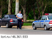 Russia, Samara. June 22, 2014. A traffic police inspector removed a license plate from a car for violating traffic rules on a sunny summer day. Text in Russian:police slow down. Редакционное фото, фотограф Акиньшин Владимир / Фотобанк Лори