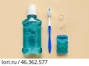 Dental floss, tooth brush and rinse on beige background. Стоковое фото, фотограф Pixel_shot / Фотобанк Лори