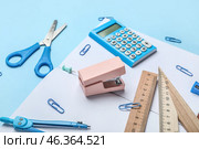 Stapler with different stationery supplies on blue background. Стоковое фото, фотограф Pixel_shot / Фотобанк Лори