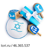 Kipa with dreidels and gift for Hannukah celebration on white background. Стоковое фото, фотограф Pixel_shot / Фотобанк Лори