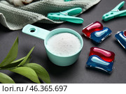 Laundry detergents, clothespins and leaves on black background. Стоковое фото, фотограф Pixel_shot / Фотобанк Лори
