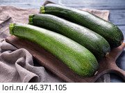 Board with ripe zucchinis on table, closeup. Стоковое фото, фотограф Pixel_shot / Фотобанк Лори