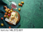 Overturned glass with cheese and fresh grapes on color table. Стоковое фото, фотограф Pixel_shot / Фотобанк Лори