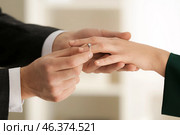 Young man putting engagement ring on fiancee's finger. Стоковое фото, фотограф Pixel_shot / Фотобанк Лори