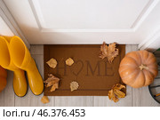 Doormat with autumn leaves, pumpkin and gumboots in hallway, top view. Стоковое фото, фотограф Pixel_shot / Фотобанк Лори