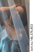 Slow motion vertical video of young female covered with veil. Woman is dressed in a peignoir and wears a necklace and earrings. Стоковое видео, видеограф Сергей Пристяжнюк (Serg Zastavkin) / Фотобанк Лори