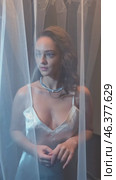 Slow motion vertical video of young female covered with veil. Woman is dressed in a peignoir and wears a necklace and earrings. Стоковое видео, видеограф Сергей Пристяжнюк (Serg Zastavkin) / Фотобанк Лори