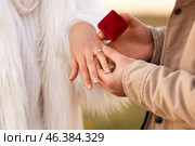 Young man putting ring on finger of his fiancee after marriage proposal outdoors, closeup. Стоковое фото, фотограф Pixel_shot / Фотобанк Лори