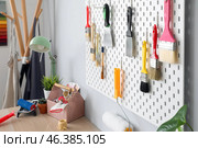 Pegboard with putty knives and brushes on light wall in decorator's workshop. Стоковое фото, фотограф Pixel_shot / Фотобанк Лори