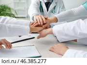 Group of doctors putting hands together in clinic. Стоковое фото, фотограф Pixel_shot / Фотобанк Лори