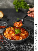 Woman eating tasty pasta and beans in bowl on table. Стоковое фото, фотограф Pixel_shot / Фотобанк Лори