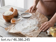 Woman sifting rice flour at table. Стоковое фото, фотограф Pixel_shot / Фотобанк Лори
