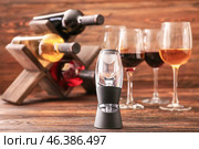 Wine aerator with bottles and glasses on wooden background. Стоковое фото, фотограф Pixel_shot / Фотобанк Лори