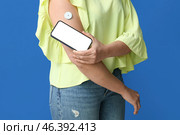 Woman with glucose sensor for measuring blood sugar level and phone on blue background. Diabetes concept. Стоковое фото, фотограф Pixel_shot / Фотобанк Лори