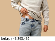 Young man with medical patch after appendix surgery on beige background, closeup. Стоковое фото, фотограф Pixel_shot / Фотобанк Лори
