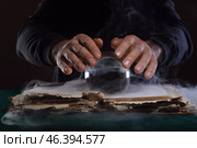 Fortune teller with crystal ball and book at table. Стоковое фото, фотограф Pixel_shot / Фотобанк Лори