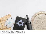 Passover Seder plate with wine, Jewish cap, matzo and Torah on white background. Стоковое фото, фотограф Pixel_shot / Фотобанк Лори
